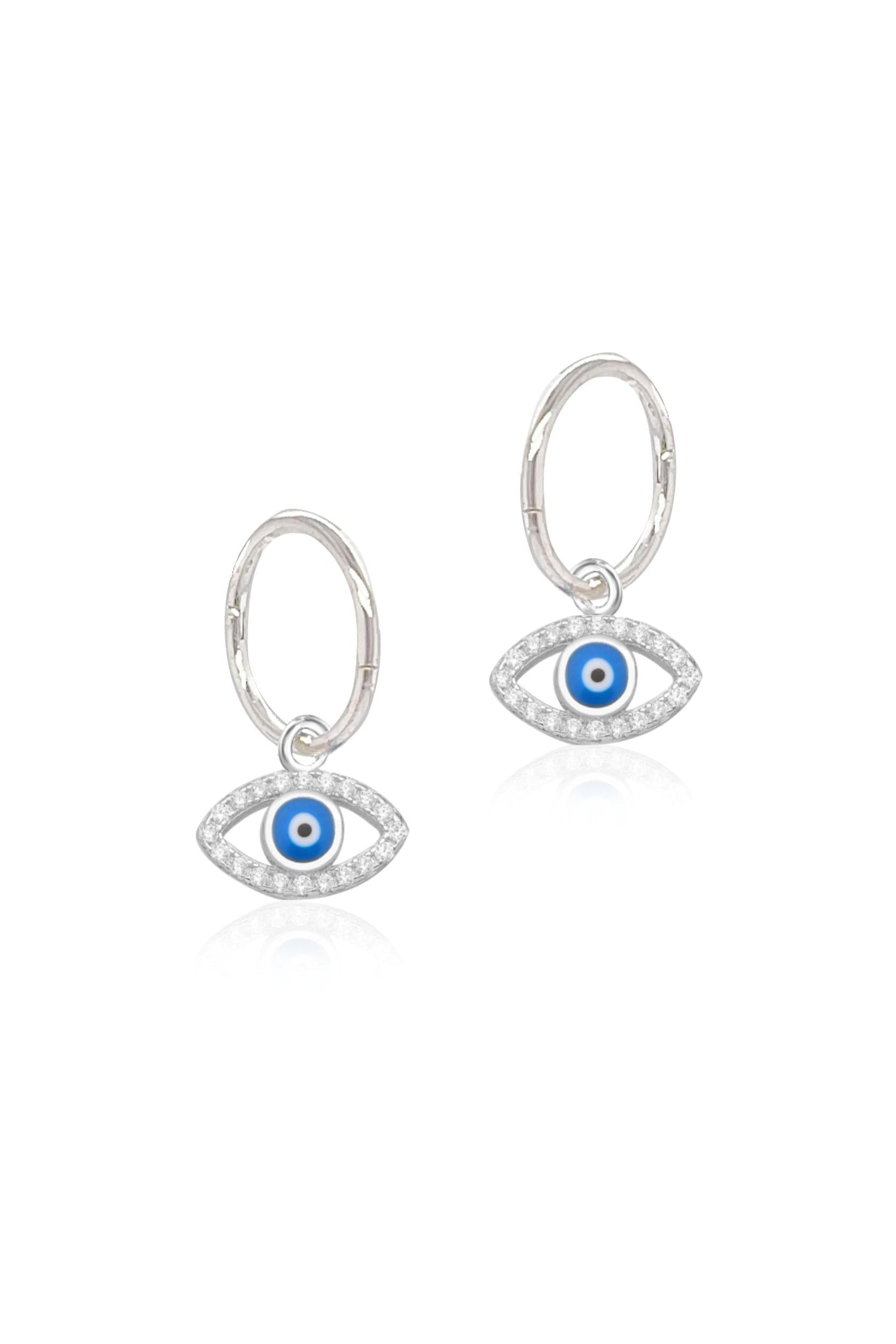 Cubic zirconia evil eye charms and sleeper earrings in sterling silver on a white background